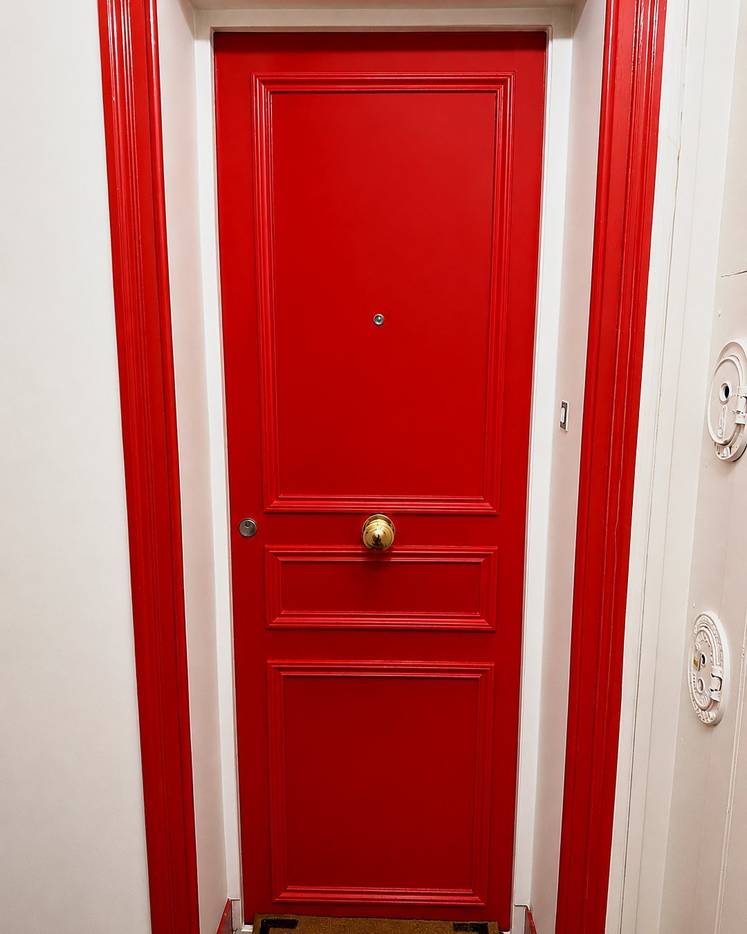 Bloc parisien certifié with red-lacquered mouldings and a central brass knob, landing side
